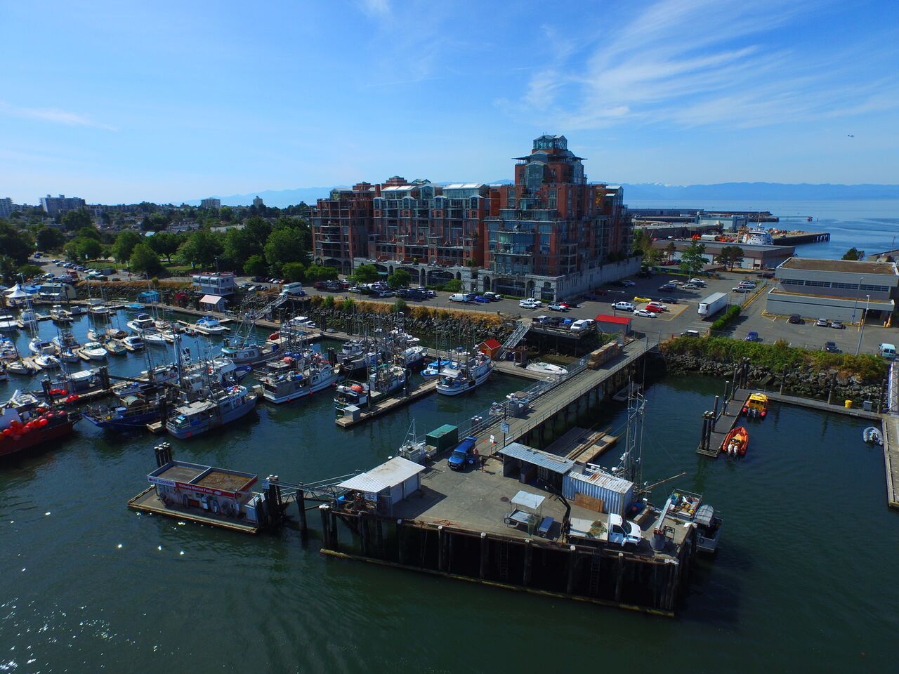 Aerial view of Victoria marina with docks, boats, and surrounding waterfront under cloudy skies.